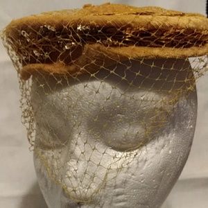 A vintage gold ladies feather/netting hat 1950s